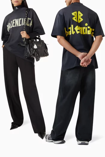 تي شيرت بقصة فضفاضة قليلاً وشعار الماركة بتصميم شريط جيرسيه فينتج للجنسين